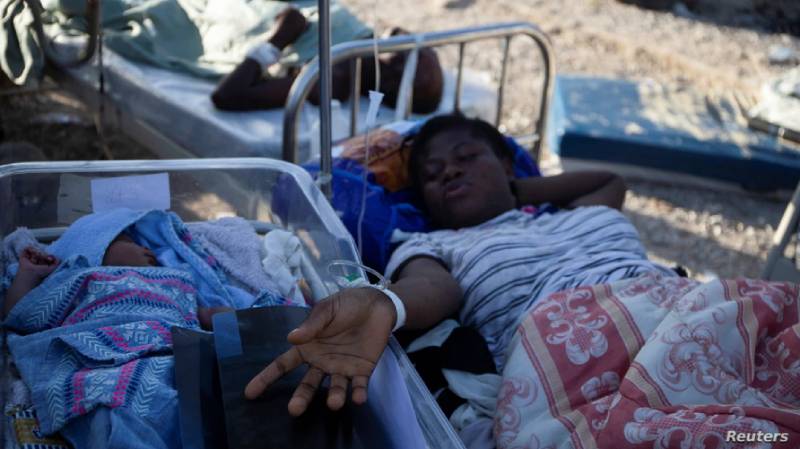 Una mujer en una camilla es fotografiada junto a un bebé después del terremoto de magnitud 7,2 en Les Cayes. 